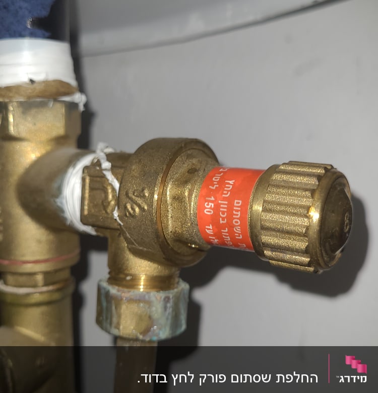 שסתום פליז עם תווית אדומה בצינור דוד שמש
